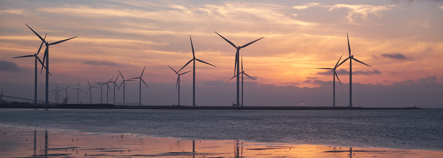Windmolens bij zonsondergang in zee