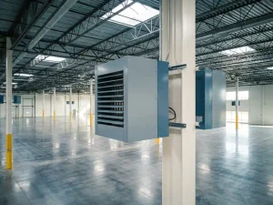Nieuwe industriële luchtverwarmer gemonteerd op een stalen kolom in een modern distributiecentrum met betonvloer en dakramen.